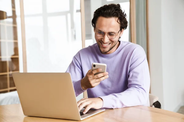 Attractive Cheerful Young Man Sitting Kitchen Table Working Laptop Computer — Stock Photo, Image