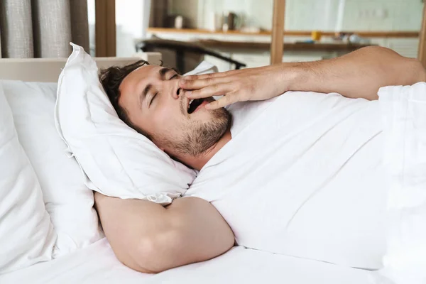 Sonriente Joven Acostado Una Almohada Cama Bostezando —  Fotos de Stock