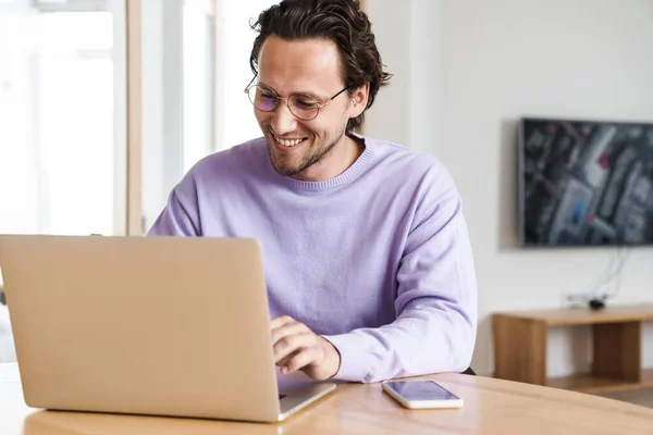 Attractive Cheerful Young Man Sitting Kitchen Table Working Laptop Computer — Stock Photo, Image