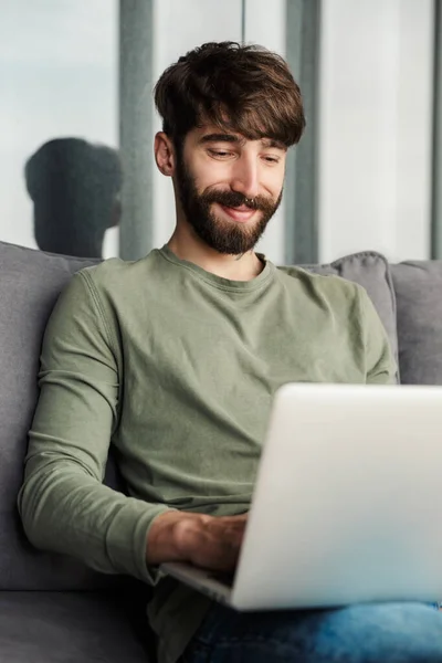 Εικόνα Ενός Χαρούμενου Νεαρού Άνδρα Casual Ντύσιμο Χρησιμοποιώντας Φορητό Υπολογιστή — Φωτογραφία Αρχείου