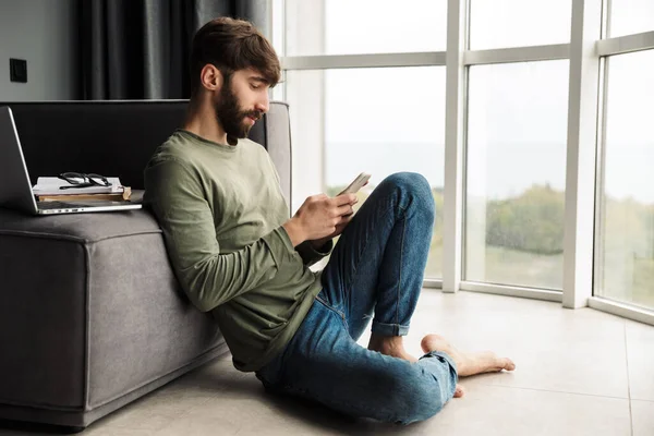 Imagen Joven Enfocado Ropa Casual Usando Teléfono Móvil Mientras Está —  Fotos de Stock