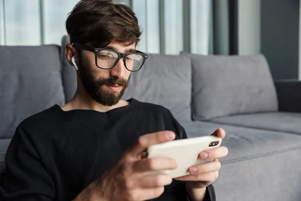 Image Focused Man Eyeglasses Using Cellphone Wireless Earphones While Sitting — Stock Photo, Image