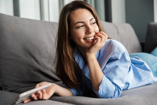 Imagen Joven Mujer Alegre Sonriendo Usando Teléfono Móvil Mientras Está — Foto de Stock