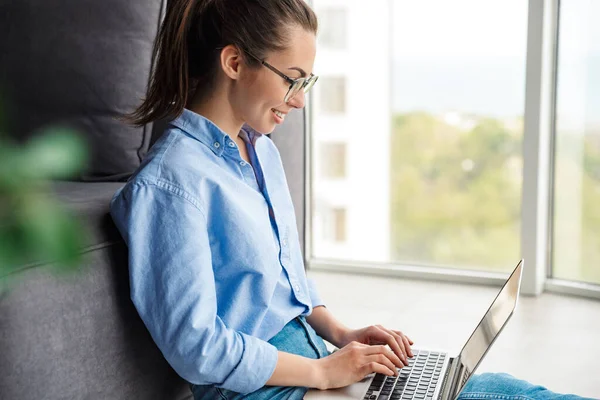 Imagem Mulher Feliz Óculos Trabalhando Com Laptop Sorrindo Enquanto Sentado — Fotografia de Stock