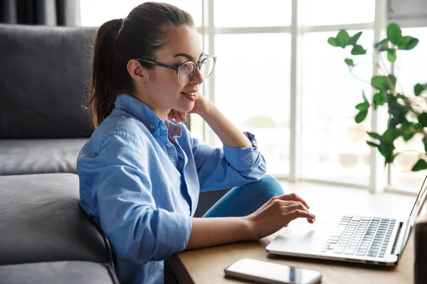 Imagem Mulher Satisfeita Óculos Trabalhando Com Laptop Sorrindo Enquanto Está — Fotografia de Stock