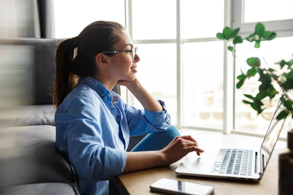 Imagem Mulher Satisfeita Óculos Trabalhando Com Laptop Sorrindo Enquanto Está — Fotografia de Stock