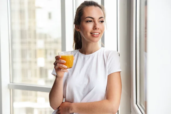 Imagen Joven Agradable Mujer Sonriendo Bebiendo Jugo Fresco Mientras Está — Foto de Stock