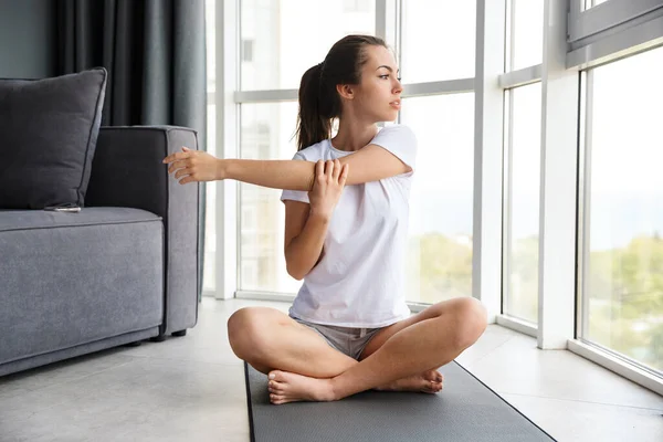 Bild Fokuserad Ung Kvinna Som Sträcker Armen Sittande Yogamattan Nära — Stockfoto