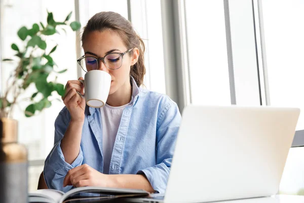 Beeld Van Slimme Mooie Vrouw Werken Met Laptop Het Drinken — Stockfoto