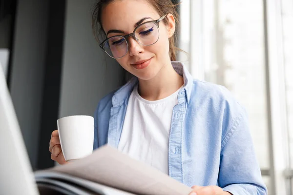 Bild Nöjd Attraktiv Kvinna Läsa Bok Och Dricka Kaffe När — Stockfoto