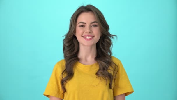 Uma Jovem Mulher Sorrindo Vestindo Camiseta Amarela Aceno Positivamente Para — Vídeo de Stock