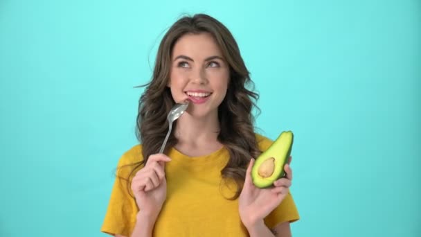Eine Fröhliche Junge Frau Gelben Shirt Hält Avocado Isoliert Vor — Stockvideo