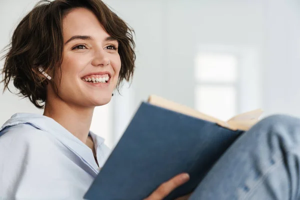 Lächelnde Junge Unternehmerin Liest Buch Während Sie Büro Sitzt — Stockfoto