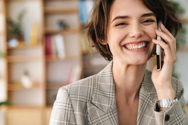 Atrakcyjnie Uśmiechnięta Młoda Bizneswoman Kurtce Rozmawiająca Przez Telefon Komórkowy Biurze — Zdjęcie stockowe