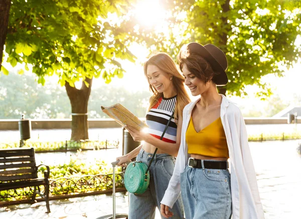Photo Two Cheerful Beautiful Women Smiling Holding Map While Walking — Stock Photo, Image
