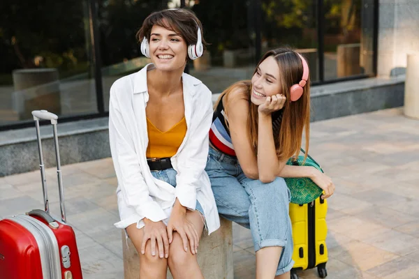 Фото Двох Щасливих Красивих Жінок Які Слухають Музику Навушниках Сидячи — стокове фото