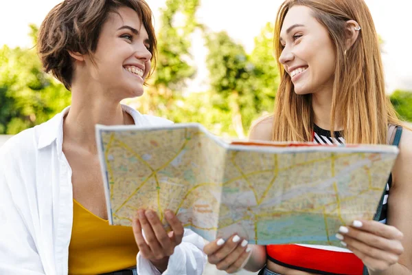 Foto Dos Mujeres Turísticas Caucásicas Sosteniendo Mirando Mapa Papel Mientras — Foto de Stock