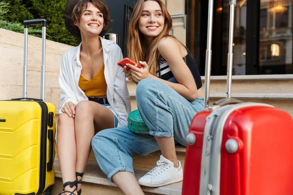 Foto Två Vackra Turist Kvinnor Som Använder Mobiltelefon Och Sitter — Stockfoto