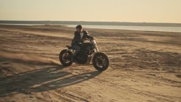 Jovem Brutal Monta Uma Motocicleta Praia Durante Pôr Sol — Vídeo de Stock