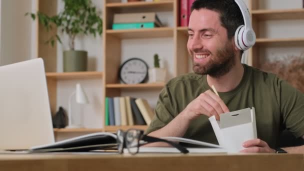 Щасливий Усміхнений Молодий Чоловік Дивиться Щось Цікаве Свій Ноутбук Сидячи — стокове відео