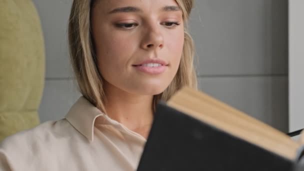 Despreocupado Atractiva Mujer Rubia Leyendo Libro Mientras Está Sentado Silla — Vídeos de Stock