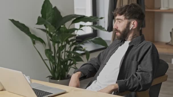 Çekici Genç Bir Dijital Sanatçı Ofiste Oturmuş Kulaklıklarını Kullanarak Akıllı — Stok video