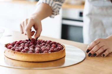 Kafkasyalı bir kadının modern mutfakta ahudududulu turta pişirirken görüntüsü.