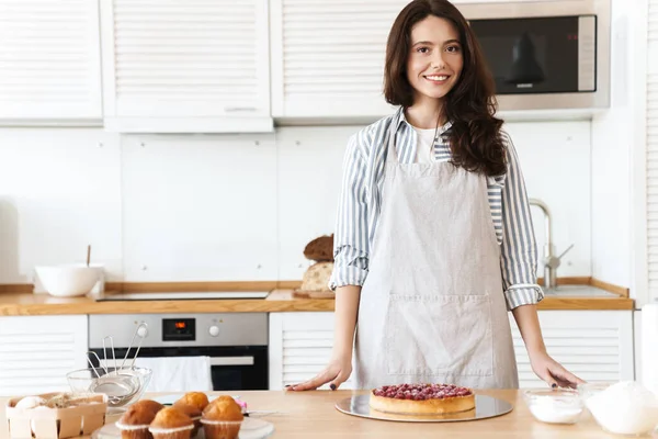 Modern Mutfakta Turta Pişirirken Önlük Giymiş Gülümseyen Esmer Bir Kadın — Stok fotoğraf