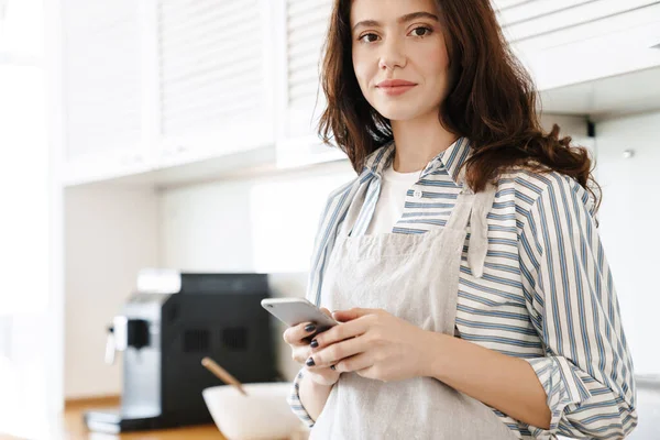 Immagine Una Donna Bruna Soddisfatta Che Indossa Grembiule Usando Cellulare — Foto Stock