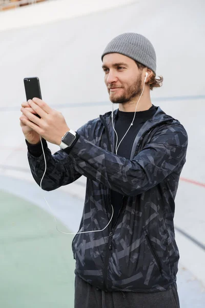 Desportista Jovem Sorridente Motivado Que Ouve Música Com Fones Ouvido — Fotografia de Stock