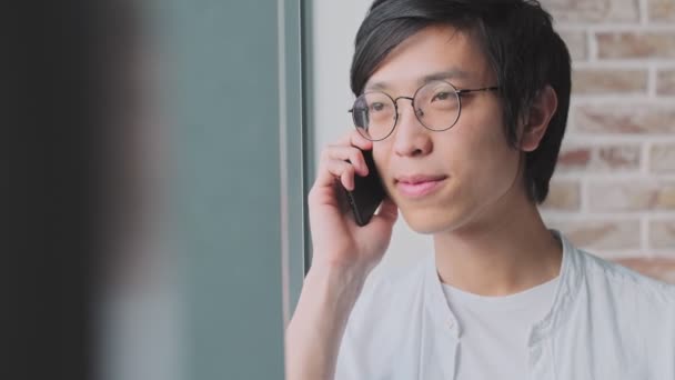 Joven Asiático Sonriente Positivo Está Hablando Teléfono Inteligente Pie Cerca — Vídeo de stock