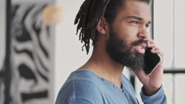 Joven Afroamericano Tranquilo Relajado Está Hablando Teléfono Inteligente Sala Estar — Vídeo de stock