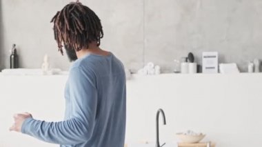 Rahat ve genç bir Afrikalı Amerikalı adamın arka planda dans edişini izliyoruz.