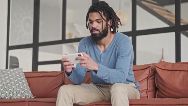 Focused Concentrated Young African American Man Playing Games Smartphone Living — Stock Video