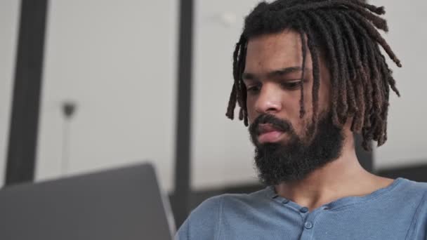 Dobře Vypadající Seriózní Afroameričan Používá Svůj Stříbrný Notebook Který Sedí — Stock video