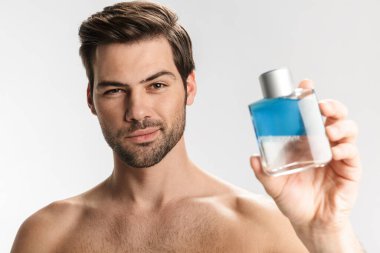 Küstah yarı çıplak bir adamın beyaz arka planda izole edilmiş parfüm pozu ve görüntüsü.
