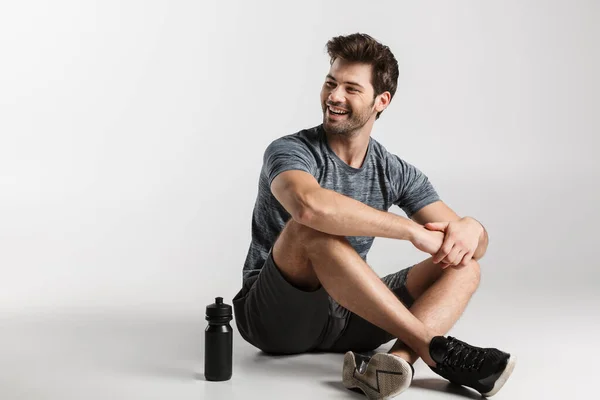 Sonriente Joven Deportista Sentado Aislado Sobre Fondo Gris Descansando Después — Foto de Stock