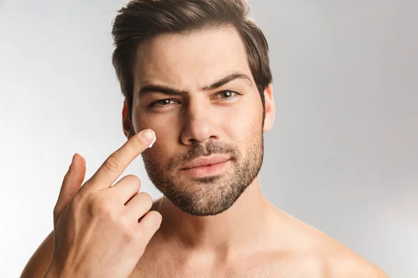 Photo Handsome Half Naked Man Looking Camera Applying Facial Cream — Stock Photo, Image