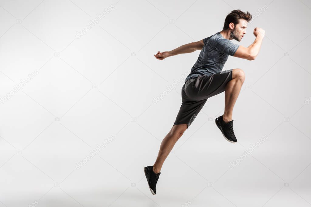Image of young athletic man in sportswear doing exercise while working out isolated over white background