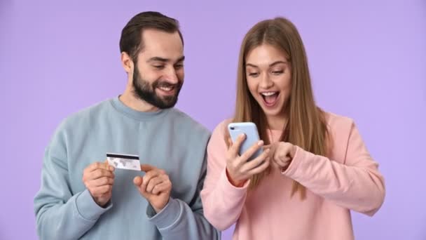 Fröhliches Junges Paar Kauft Auf Smartphone Mit Kreditkarte Ein Und — Stockvideo