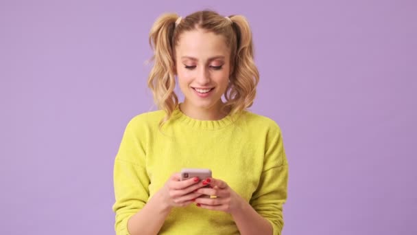 Unforgettable Blonde Smiles Writes Messages Isolated Studio Purple Background — Stock Video