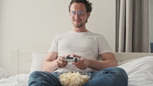 Homem Bonito Feliz Óculos Jogando Console Com Gamepad Enquanto Sentado — Vídeo de Stock