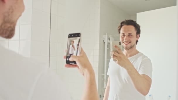 Engraçado Bonito Homem Fazendo Selfie Smartphone Espelho Piscando Com Olho — Vídeo de Stock