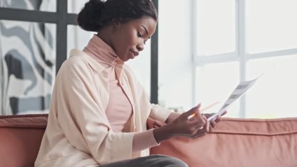 Een Behoorlijk Gefocuste Jonge Afrikaanse Vrouw Kiest Nieuwe Kleuren Voor — Stockvideo