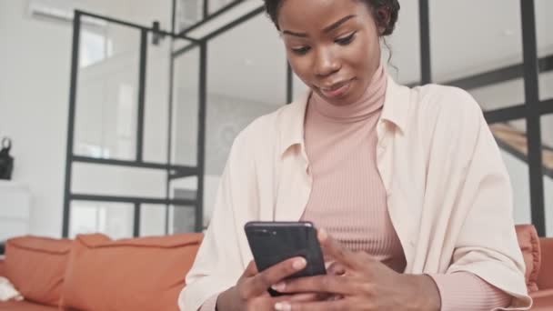 Een Tevreden Glimlachende Jonge Afrikaanse Dame Gebruikt Haar Mobiele Telefoon — Stockvideo