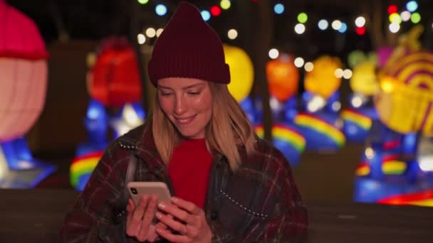 Zaintrygowana Młoda Blondynka Nosi Jesienne Ubrania Pomocą Smartfona Następnie Raduje — Wideo stockowe