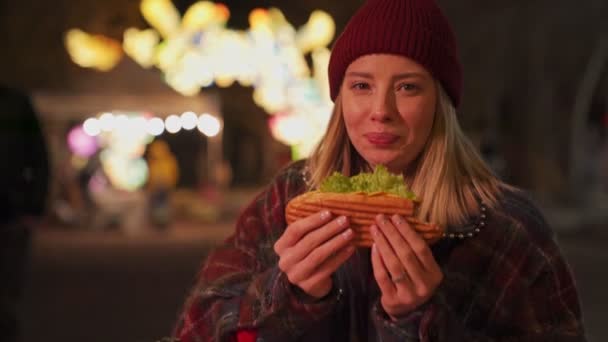 Sonbahar Kıyafetleri Giyen Neon Işıklı Arka Planda Sandviç Yiyen Mutlu — Stok video