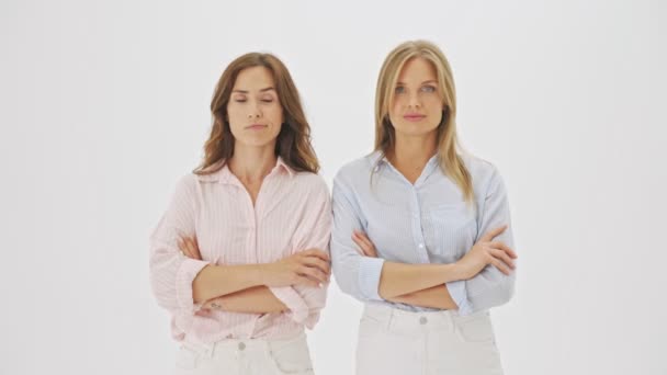 Δύο Δυσαρεστημένες Γυναίκες Αντιπαθούν Μία Την Άλλη Στέκονται Απομονωμένες Λευκό — Αρχείο Βίντεο