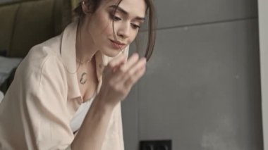 Genç, güzel, pozitif kadın evde kalemle notlar yazıyor.