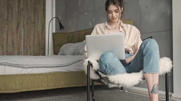 Jovem Mulher Positiva Sentado Dentro Casa Usando Computador Portátil — Vídeo de Stock